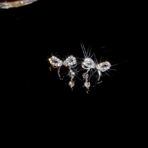 Boucles d'oreilles double nœud étincelantes avec diamants et tiges en argent sur miroir