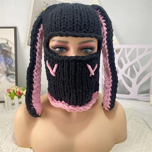 Close-up of black handmade knit balaclava with long rabbit ears and pink cross details