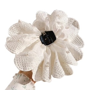Elegant white floral hair claw with lace petals and pearls for a romantic hairstyle
