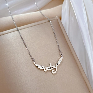 Dettaglio della collana in acciaio al titanio argento con ciondolo ala baby su display