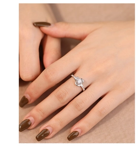 Detailed close-up of a silver rose flower ring with cubic zirconia on a female finger