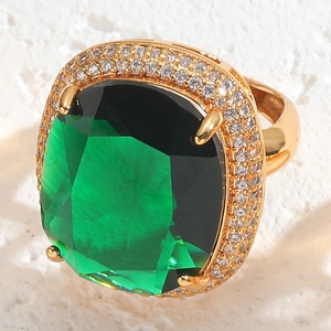 Macro shot of a 14K gold-plated ring featuring a square emerald-green gemstone and zircon