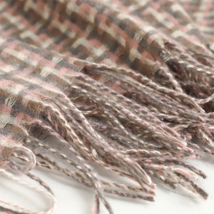 Close-up of pink and beige plaid scarf showing soft cashmere texture and long tassels