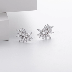 Macro shot of silver flower earrings with marquise and round zircon stones on minimalist base