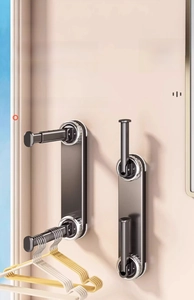 Detail of wall-mounted suction cup clothes rack with foldable telescopic arms in black