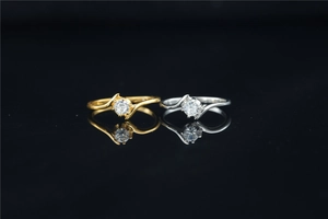 Close-up of gold and silver crossover rings with brilliant round-cut moissanite stones