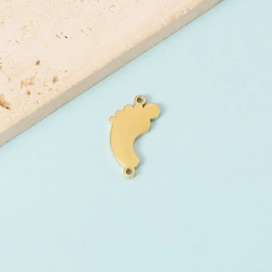 Detailed view of gold baby feet charm with MOM letter and dual rings on a blue background