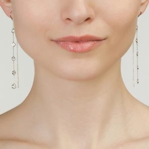 Detail of silver long tassel earrings with sparkling round zircon stones on model