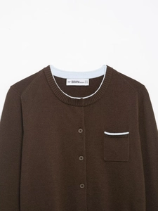Detail of dark brown knit cardigan featuring light blue contrast trim and round neckline