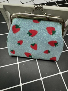 Top view of a light blue strawberry pattern coin purse with silver metal clasp closure