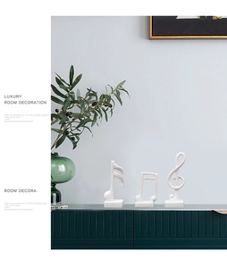 Three white musical note sculptures on a dark green cabinet with a minimalist interior design