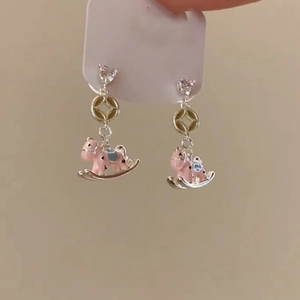 Pink enamel rocking horse earrings with heart-shaped diamonds and golden geometric links