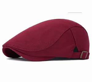 Detail view of wine red flat cap for men with adjustable bronze metal buckle on side