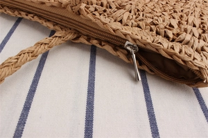 Close-up of paper rope woven shoulder bag featuring a silver metal zipper closure