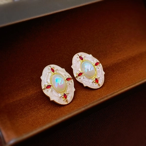 Détail de boucles d'oreilles vintage style palais avec cristaux rouges en écrin