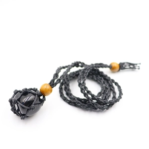Detail of hand-woven black mesh necklace with polished stone and wooden beads
