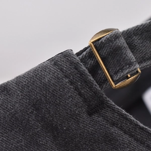 Detail of dark grey corduroy baseball cap with vintage bronze metal buckle and strap