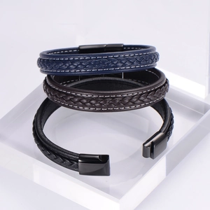 Detail of woven leather bracelets in black, brown, and blue with magnetic metal clasps