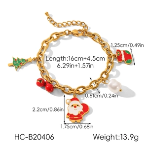 Détail du bracelet chaîne doré avec breloques sapin de Noël, Père Noël et clochettes
