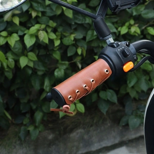 Close-up of vintage brown leather motorcycle handle covers with retro lace-up metal eyelets