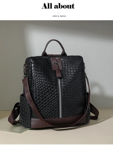 Close-up of woven black leather backpack with brown trim and vertical silver zipper detail