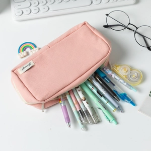 Pink canvas pencil pouch with large capacity storage for pens and stationery on white desk