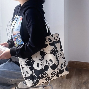 Detailed side view of large canvas tote bag with panda prints on shoulder