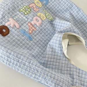 Detail of blue and white checkered seersucker tote bag with colorful embroidered letters