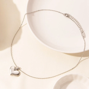 Detail of silver heart pendant necklace with S.Steel hallmark tag and lobster clasp