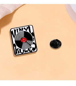 Detail of square vinyl record enamel pin with Vinyl Rules text and rubber back
