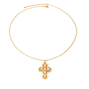 Detailed flat lay of golden cross necklace with white pearls and colorful rhinestones