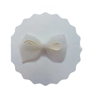 Detail of white mesh bow hair accessory with pink striped ribbon and central cord knot