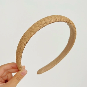 Close-up of the intricate straw woven texture and smooth inner lining on the brown headband