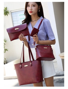 Detail view of burgundy 4-piece handbag set including tote and crossbody bag in faux leather