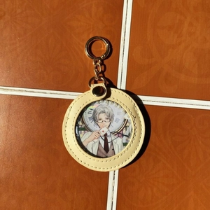 Detail of round faux leather badge holder keychain with clear window and gold ring