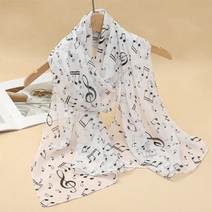 Detail of white chiffon scarf with black music note print hanging on a wooden hanger