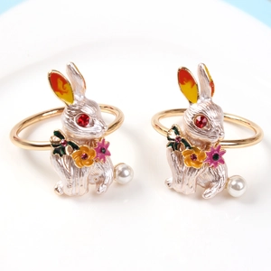 Detailed view of golden rabbit napkin ring with red rhinestone eye and pearl tail