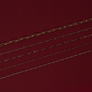 Flat lay of multiple gold-plated stainless steel necklaces with different chain link designs