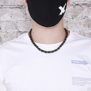 Close-up of a men's matte black chunky twist chain necklace in industrial street style