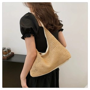 Model view of large woven tote bag showing natural straw texture and shoulder fit