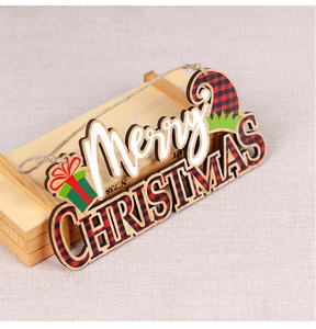 Detail of wooden Merry Christmas sign with red and black plaid pattern and jute rope