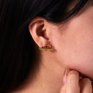 Close-up of a minimalist 18K gold plated stainless steel toggle ear stud on a model