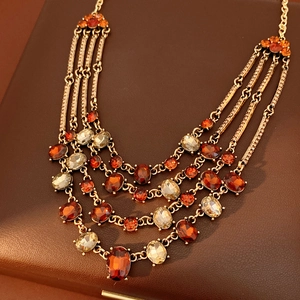 Macro detail of vintage layered gold necklace with amber and yellow crystal gemstones