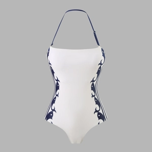 Detail of white halter neck swimsuit with blue symmetrical side patterns and adjustable strap