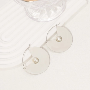 Minimalist silver semi-circle geometric earrings with white pearls in a top-down view