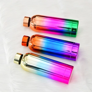 Close-up of gradient stainless steel sports bottles in gold, blue, and orange on plush
