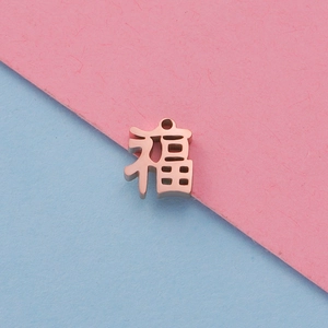 Macro-opname van roségouden Chinese Fu-hanger op roze en blauw papier