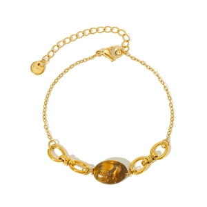 Detailed close-up of golden stainless steel bracelet featuring an oval tiger eye stone