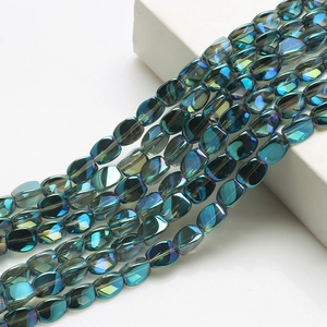 Close-up of flat oval iridescent teal crystal beads for DIY jewelry and lighting decor