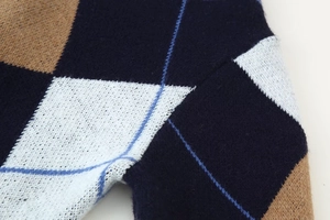 Close-up of diamond pattern knit sweater showing navy and brown woven texture